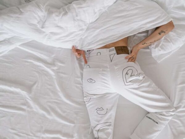 woman in white dress lying on bed