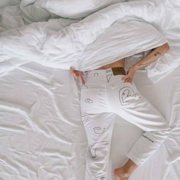 woman in white dress lying on bed