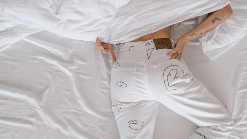 woman in white dress lying on bed