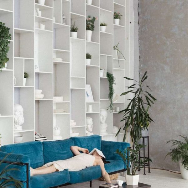 man in blue t-shirt lying on blue sofa